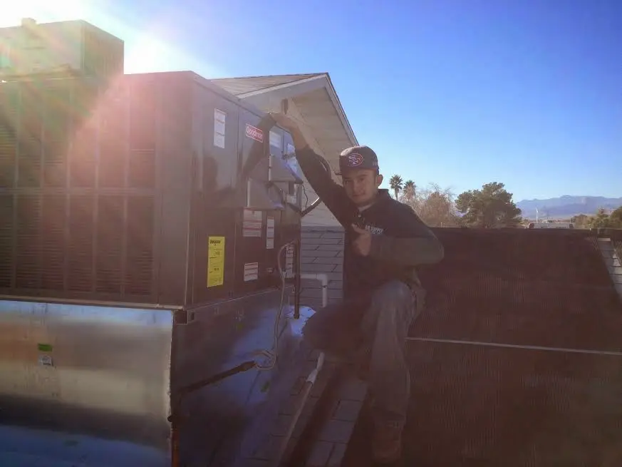 HVAC technician performing HVAC Inspection on a rooftop unit in De Soto